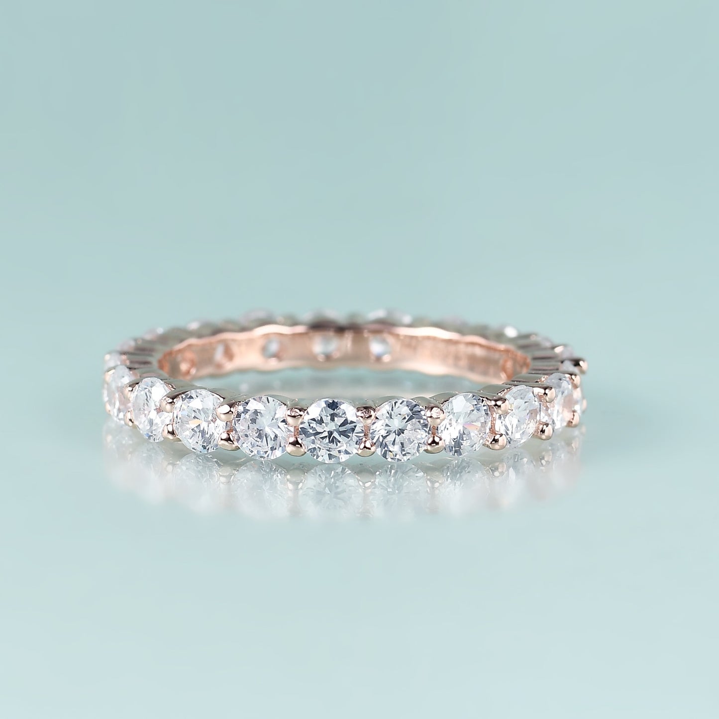 A rose gold moissanite infinity ring.