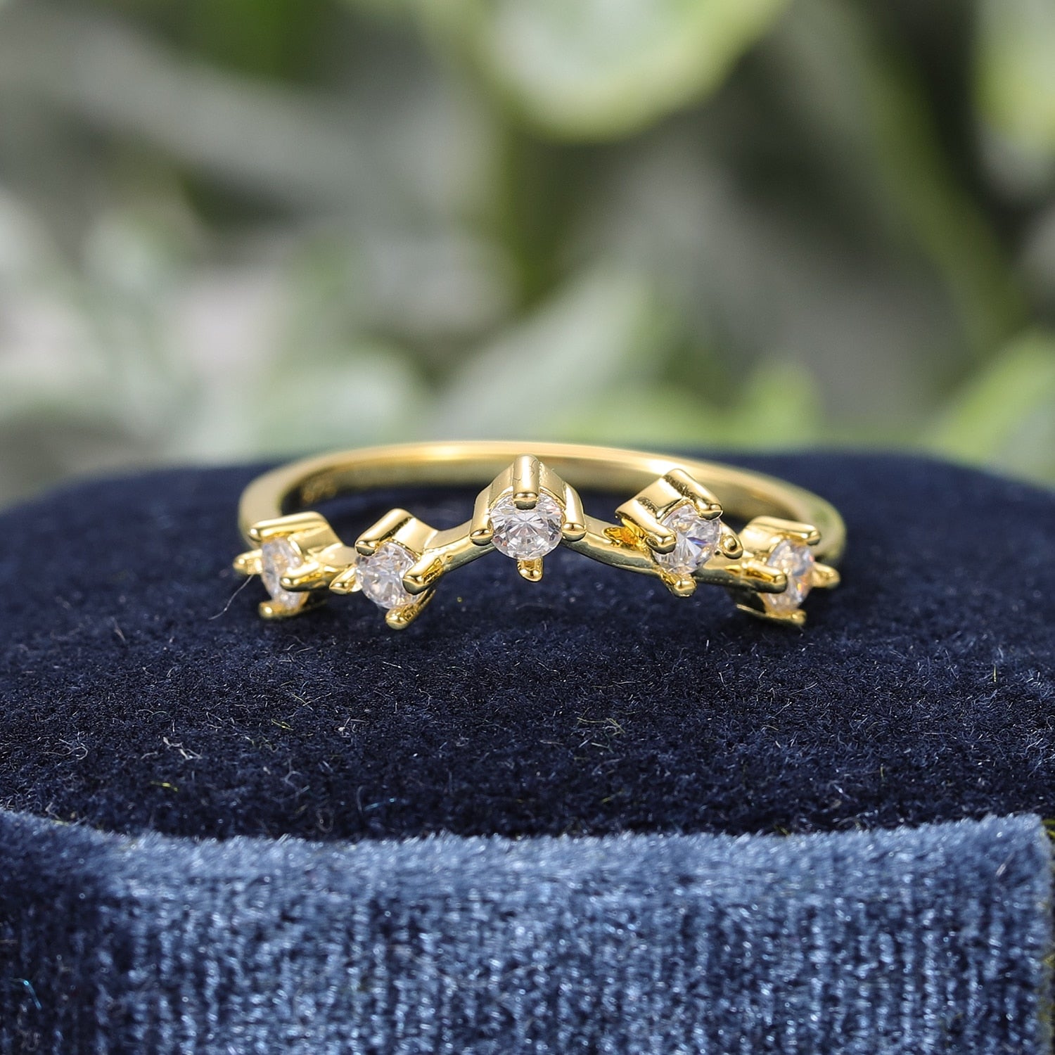 A gold chevron style wedding ring set with 5 small round spaced apart moissanites.