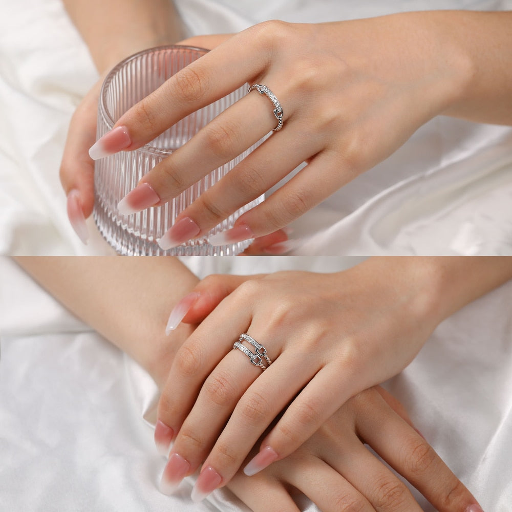 Two hands wearing two silver chain and rope style rings set with 8 horizontally set moissanites.