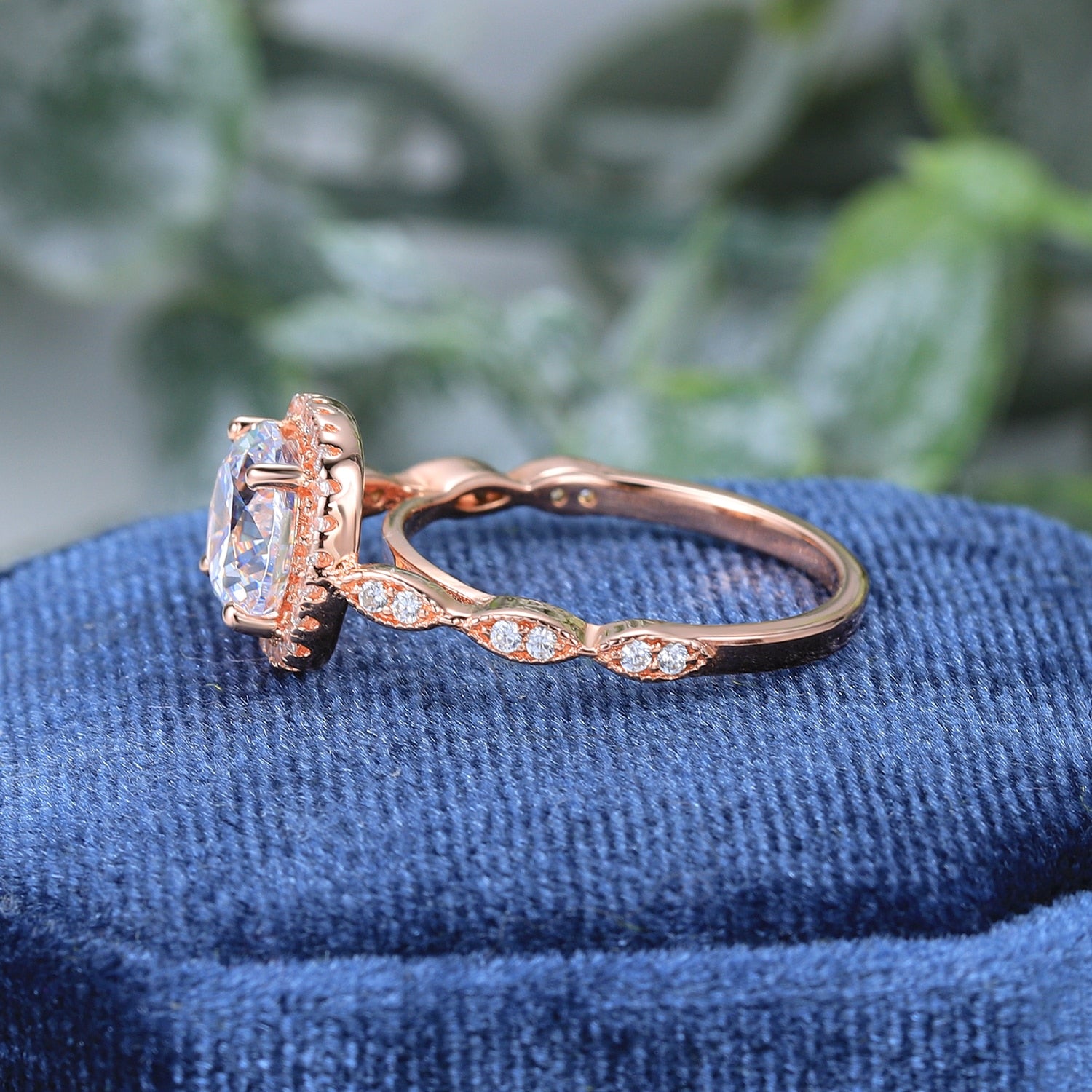 A rose gold squared halo ring set with a 2CT round moissanite on a scalloped gem encrusted band.