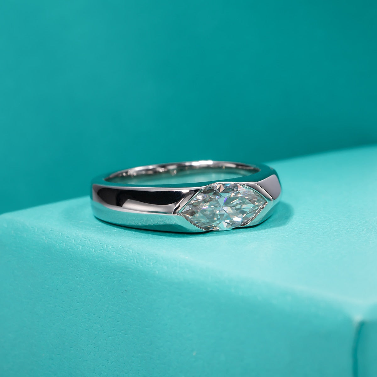 A marquise cut moissanite tension set east to west in a thick sterling silver band.