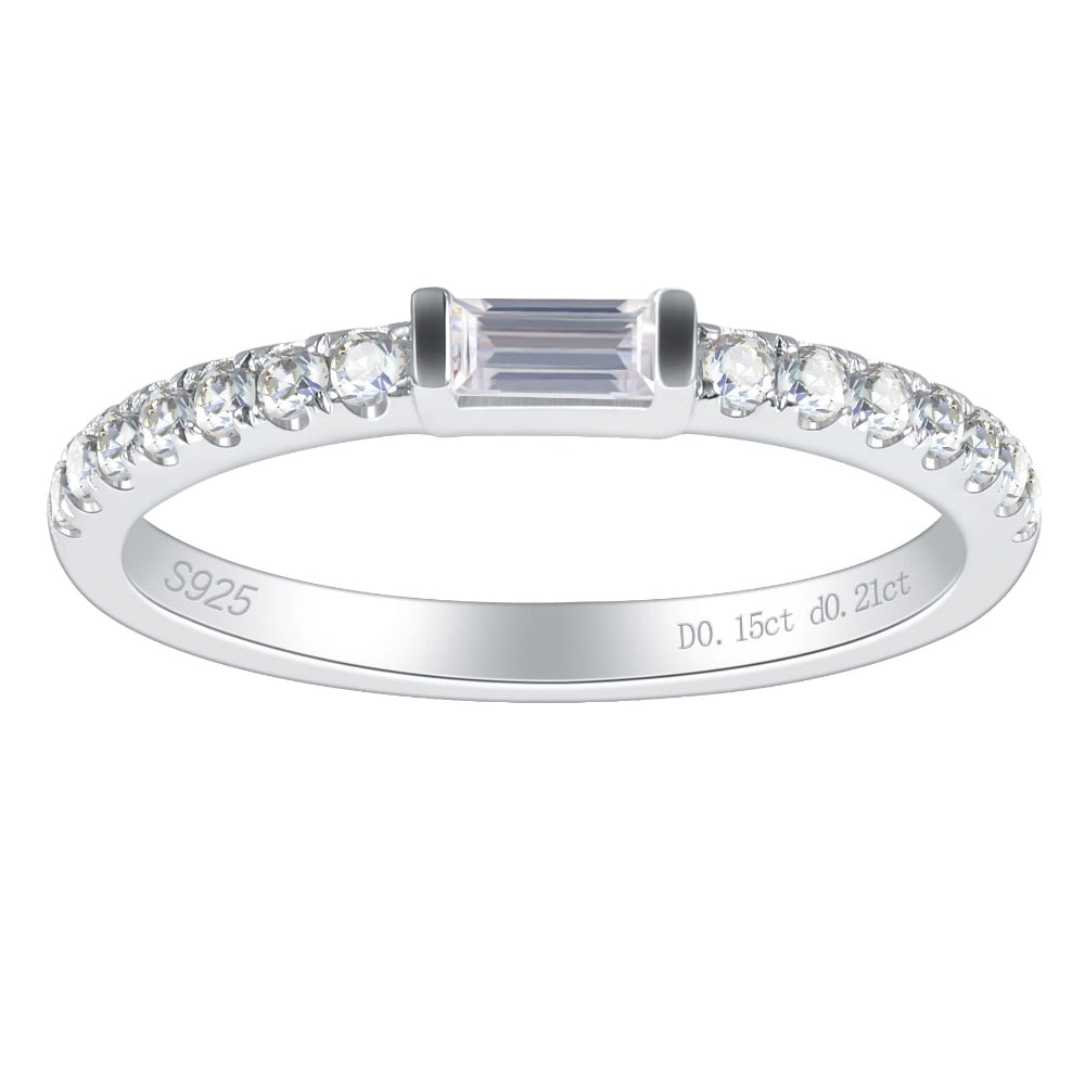 A silver stackable wedding ring tension set with a small emerald cut gem on a pave band.