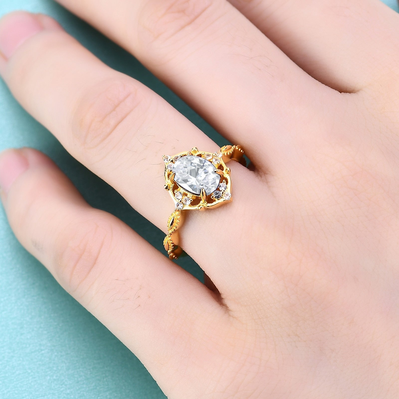 Solid yellow gold vintage style halo engagement ring set with an oval cut moissanite.