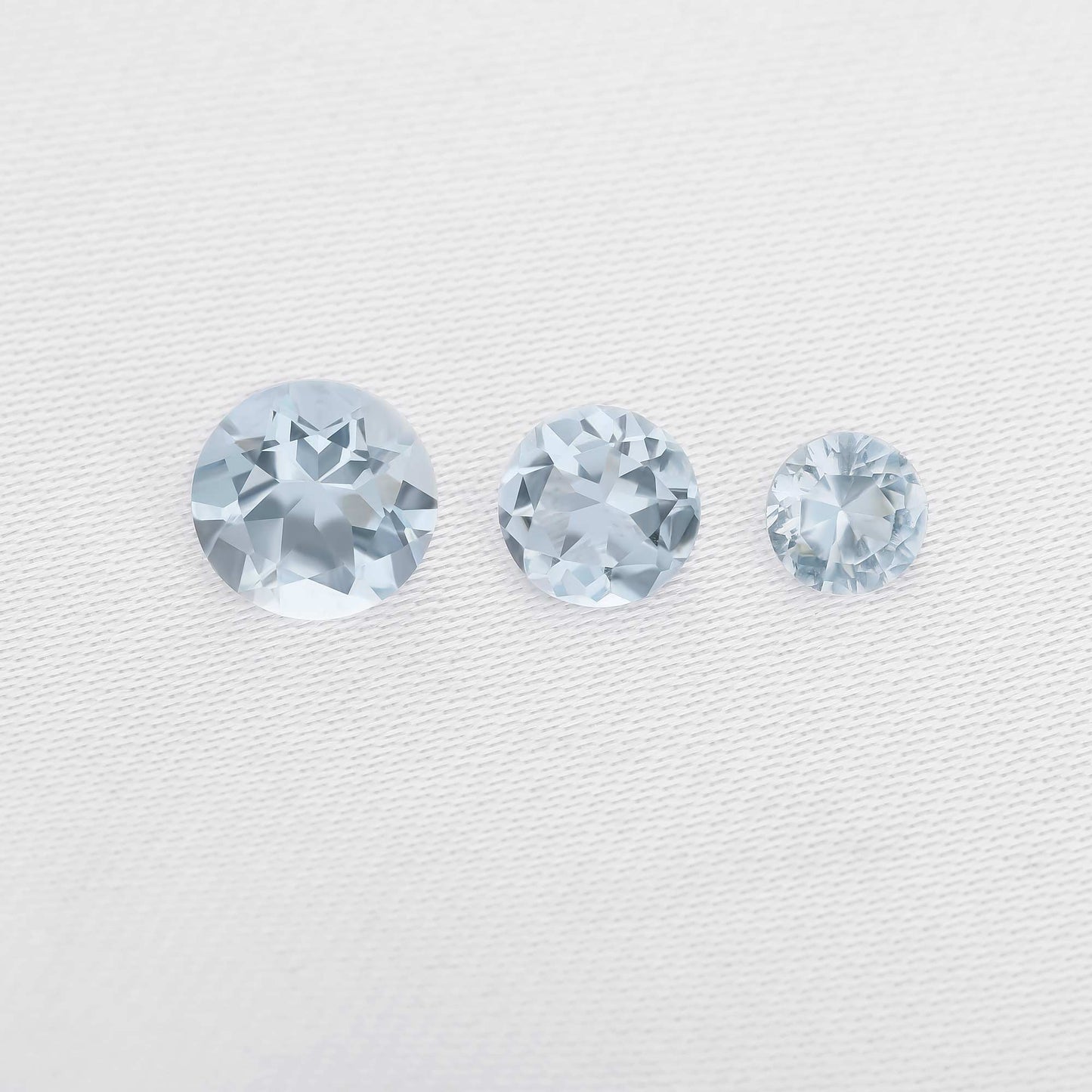 3 round cut light blue aquamarine gems.