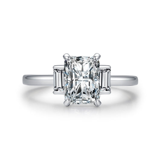 A silver ring featuring a 3CT radiant cut moissnite set between two smaller emerald cut gems.