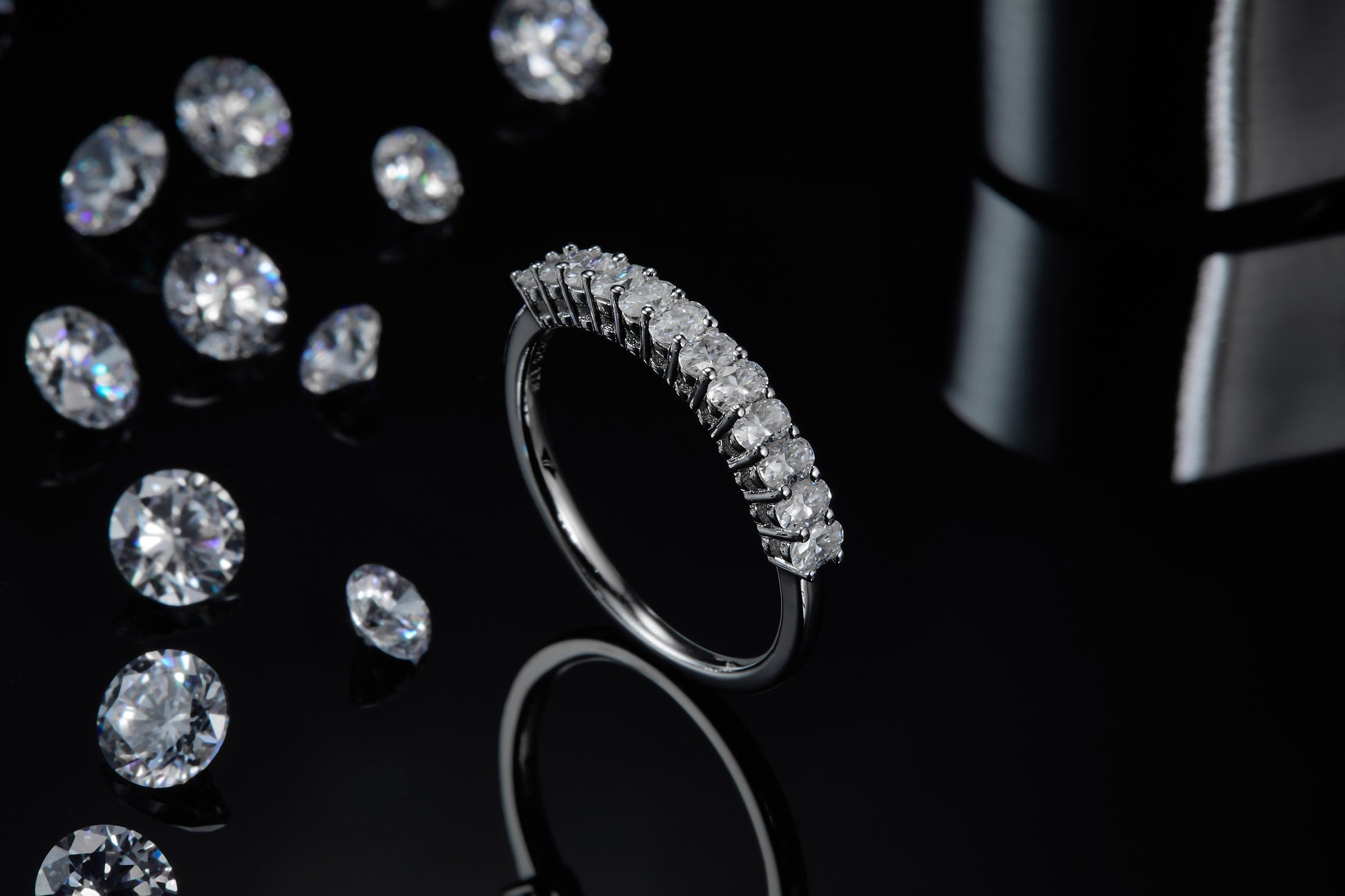A silver half eternity ring set with vertical oval cut moissanites.
