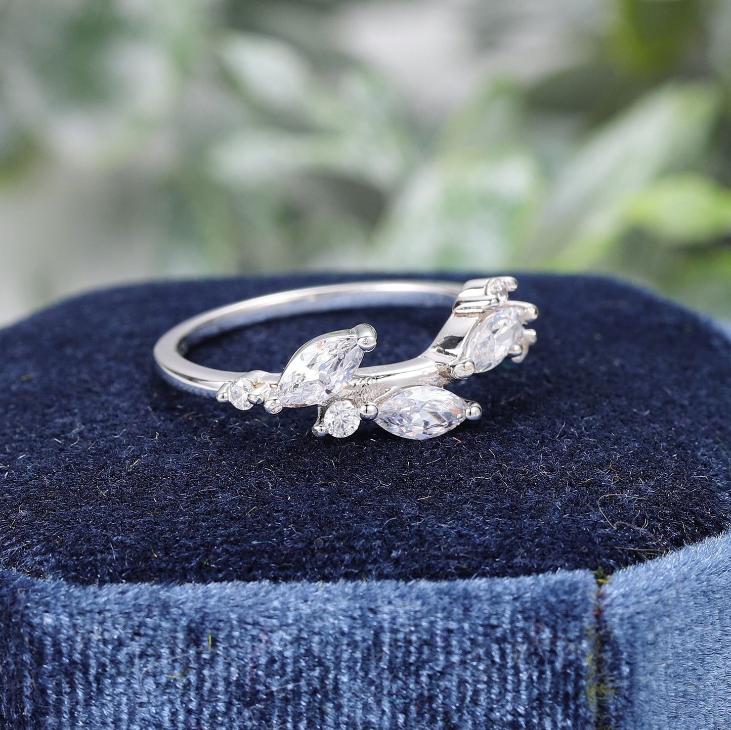A silver wedding ring with three marquise moissanite set like leaves.
