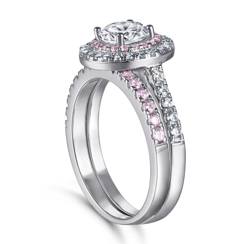 A silver double halo pink and white halo ring set with a round cut moissanite and with a matching pink eternity ring.