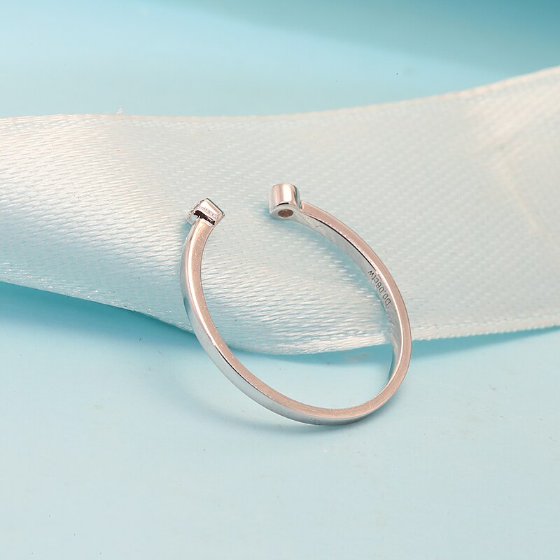 A wrap around silver wedding band with a small round bezel set moissanite on each end.