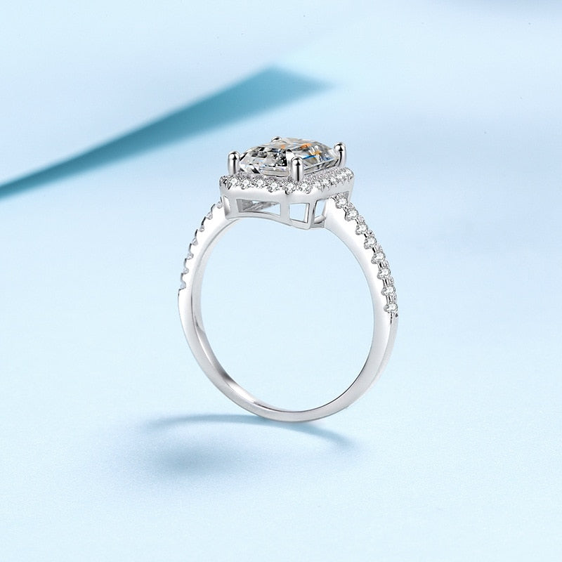 A silver halo ring set with a radiant cut moissanite.