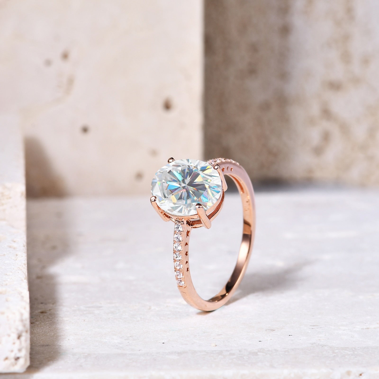 A rose gold pave band with moon and star cut outs on each side, set with a 3CT oval moissanite.