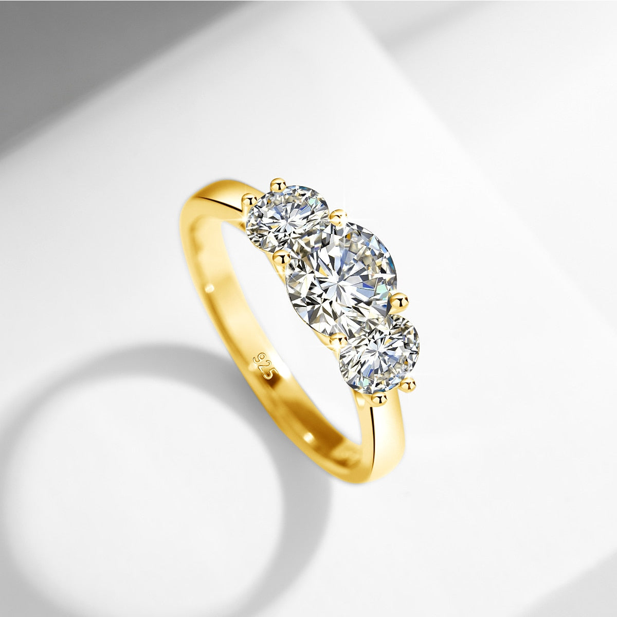 A gold 2 stone ring set with a 1CT round floating moissanite with a .5CT floating moissanite on each side.