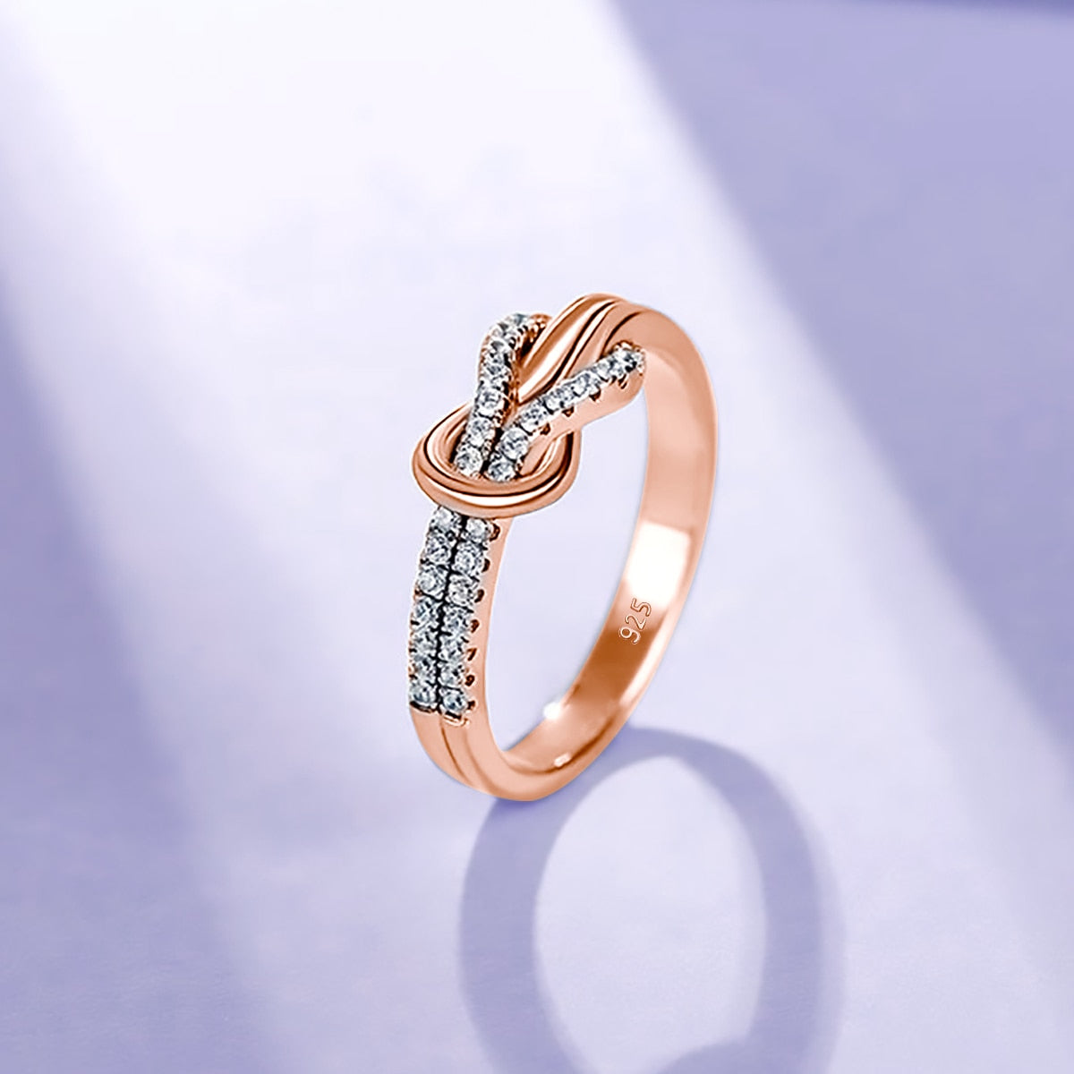 A rose gold half pave infinity knot ring.