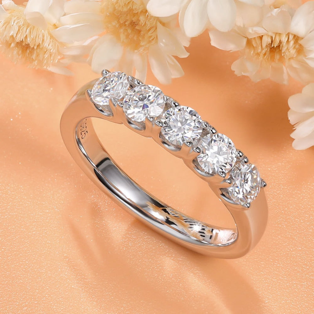A silver 5 round cut stone wedding ring.