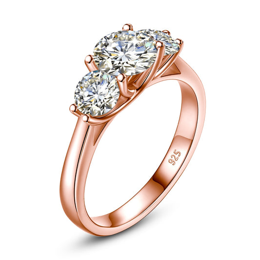 A rose gold 2 stone ring set with a 1CT round floating moissanite with a .5CT floating moissanite on each side.