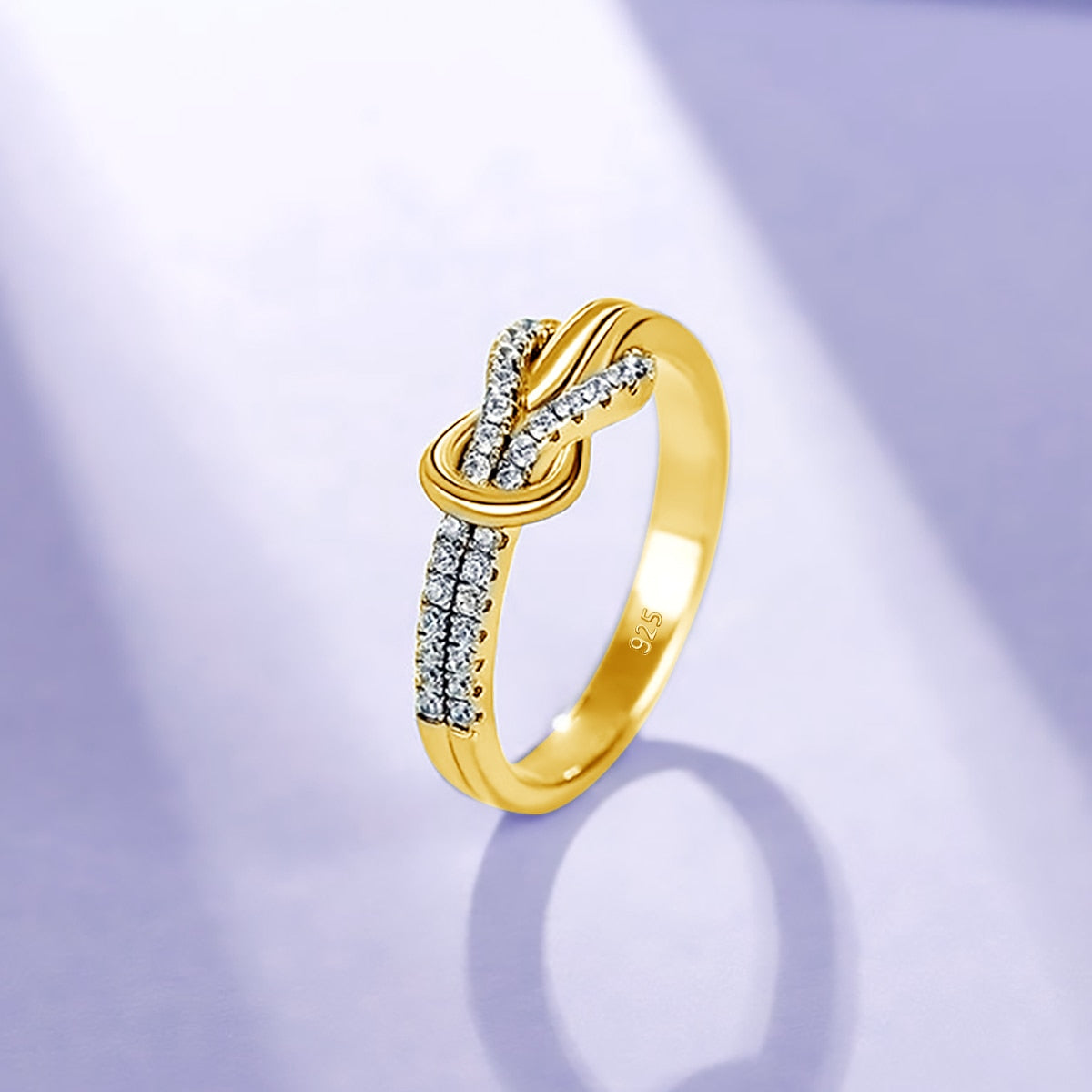 A gold half pave infinity knot ring.