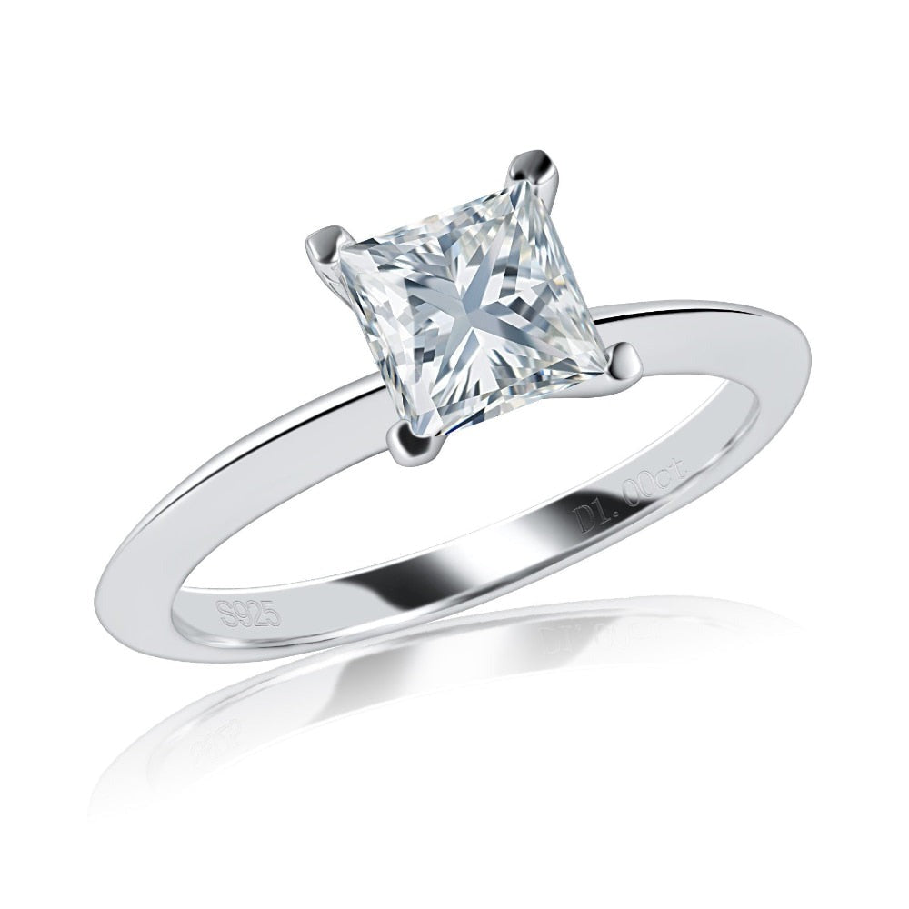 A silver engagement solitaire ring set with a princess cut moissanite.