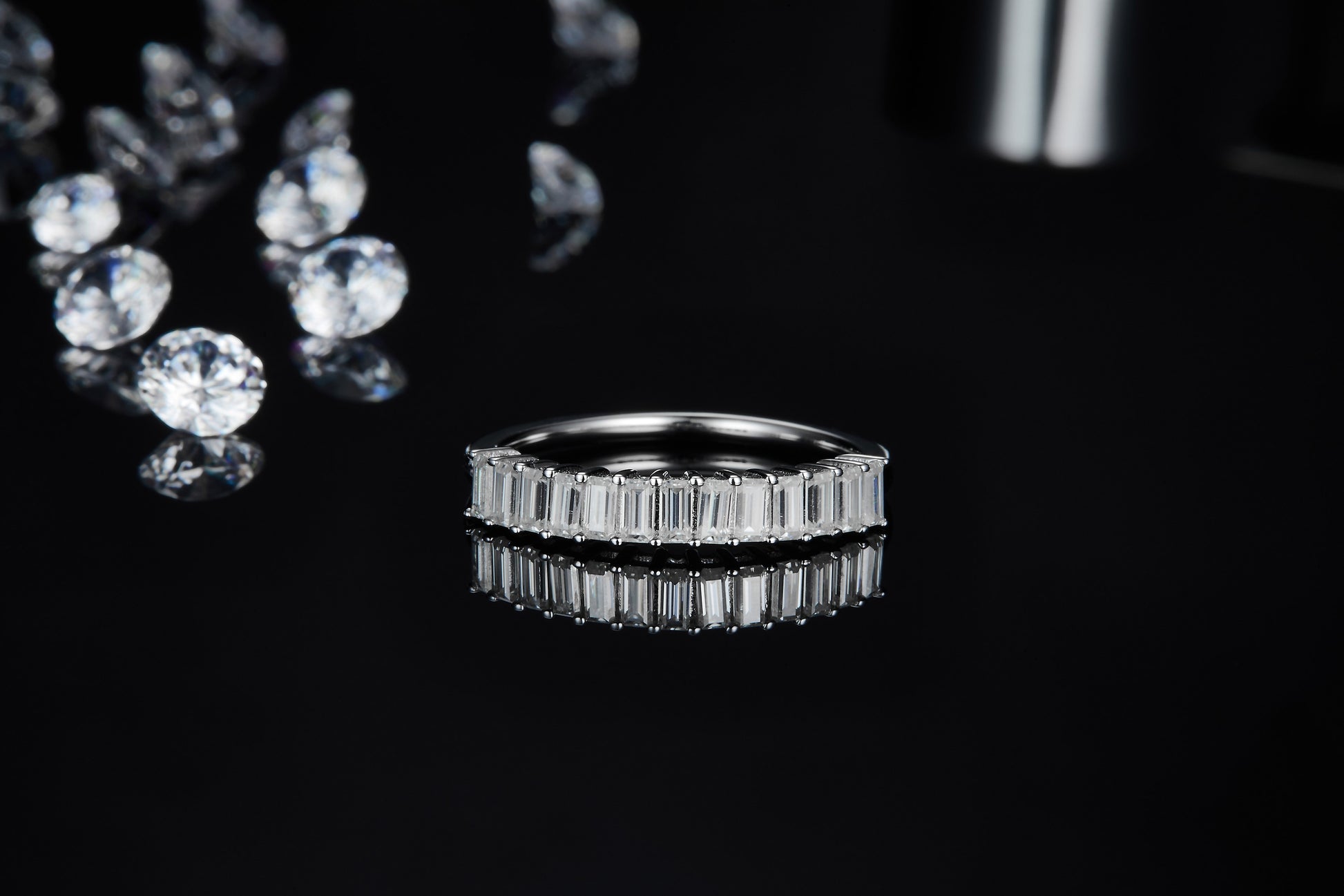 A silver partial eternity wedding ring set with vertical emerald cut moissanites.
