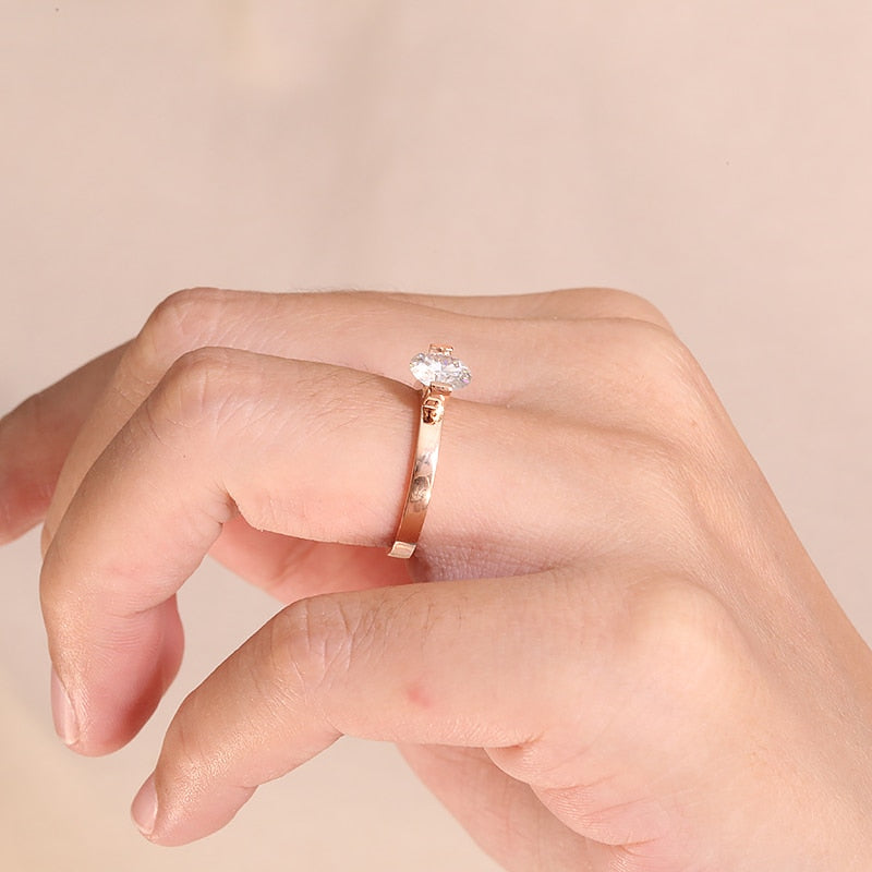 A hand wearing a gold tension set floating moissanite ring.