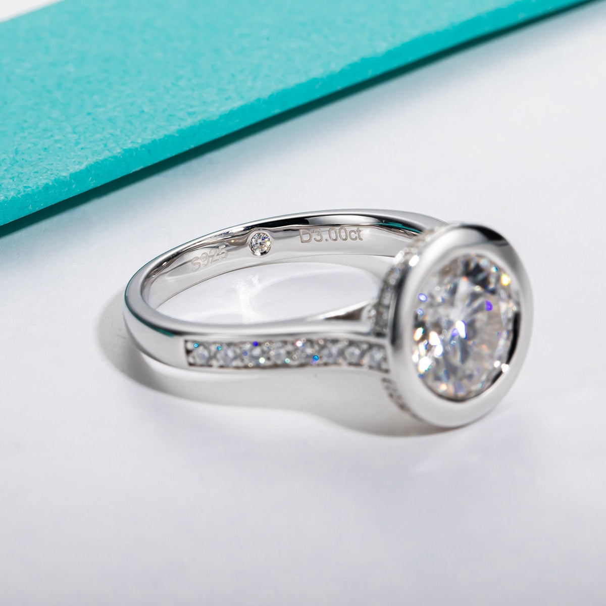 A 3CT moissanite, bezel set in a floating setting on a pave band.