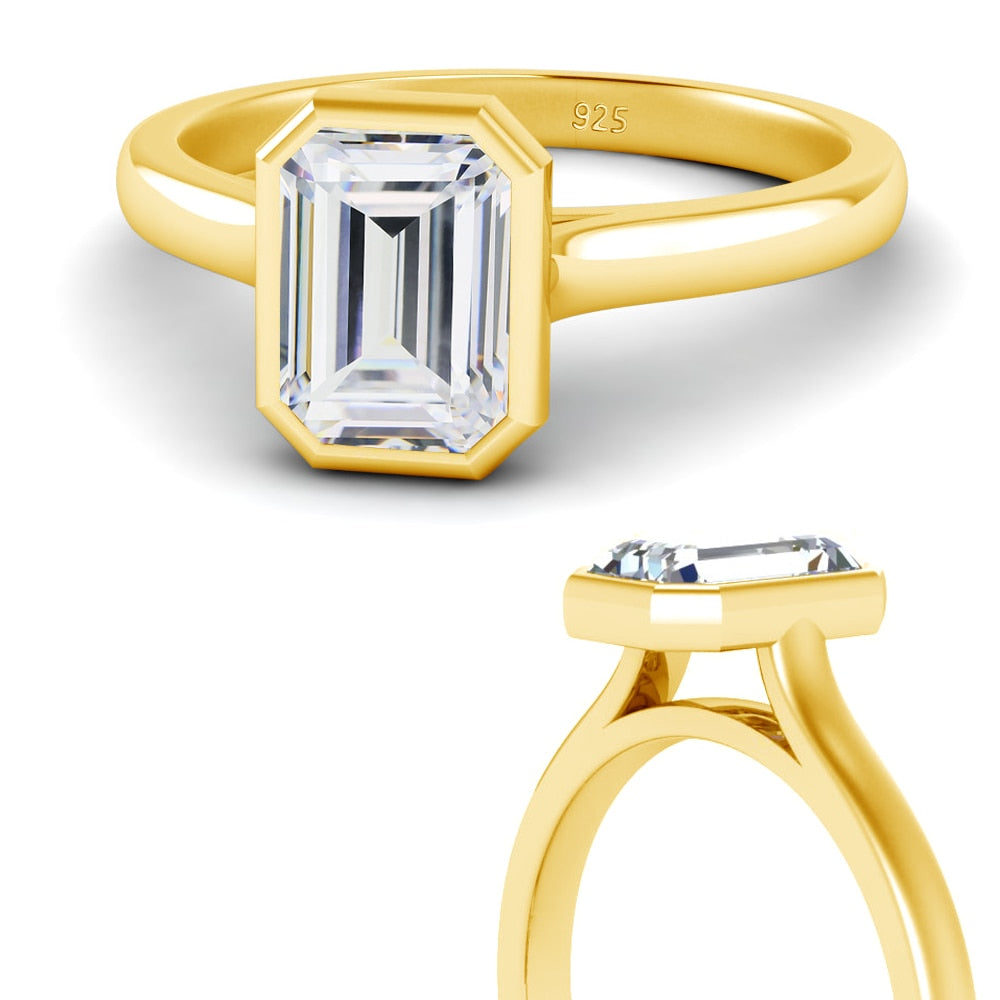 2 gold bezel set emerald cut moissanite ring.