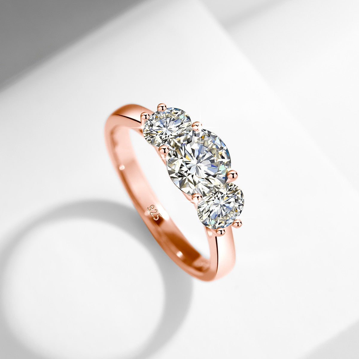 A rose gold 2 stone ring set with a 1CT round floating moissanite with a .5CT floating moissanite on each side.