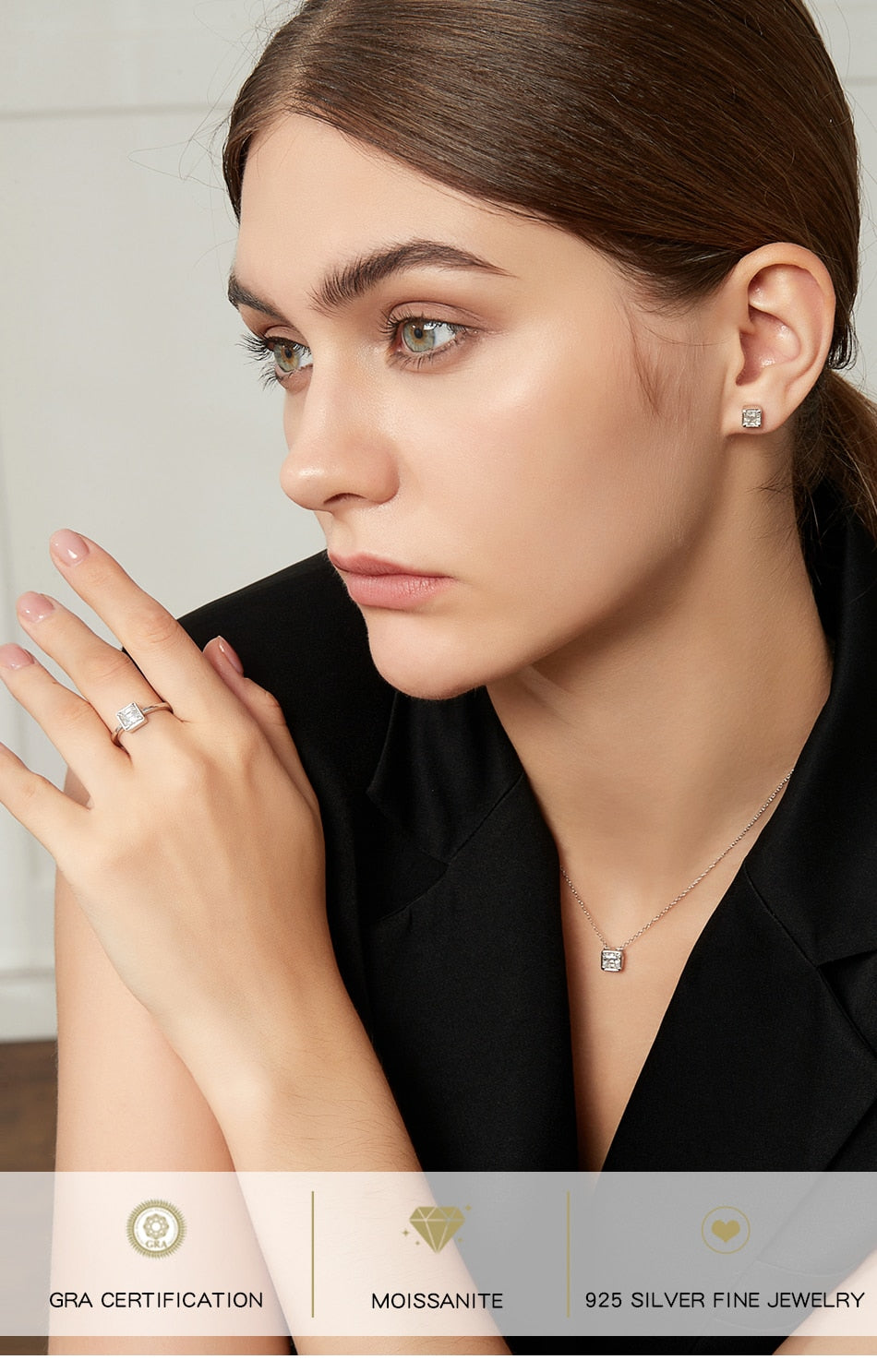 A woman wearing a silver Asscher cut bezel set engagement ring.