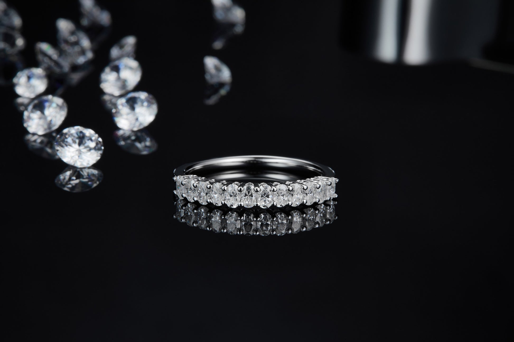 A silver half eternity ring set with vertical oval cut moissanites.