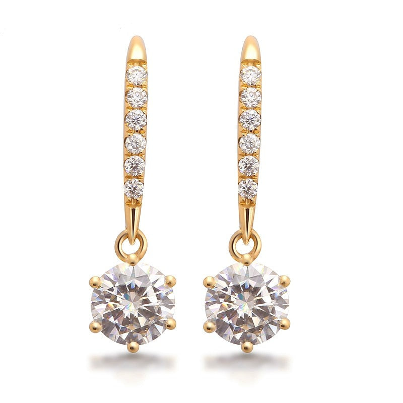 A gold pair of dangling earrings set with round clear stones.