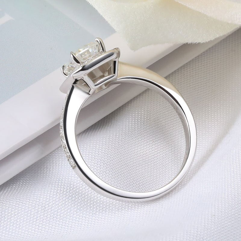 A silver emerald cut halo ring.