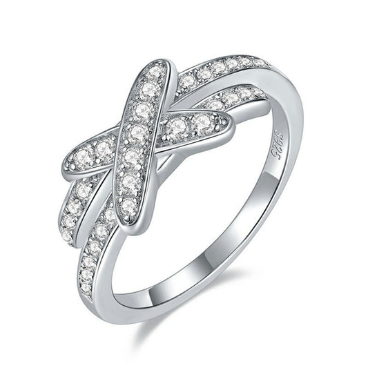 A silver pave bypass ring with a X studded with sparkling moissanites.