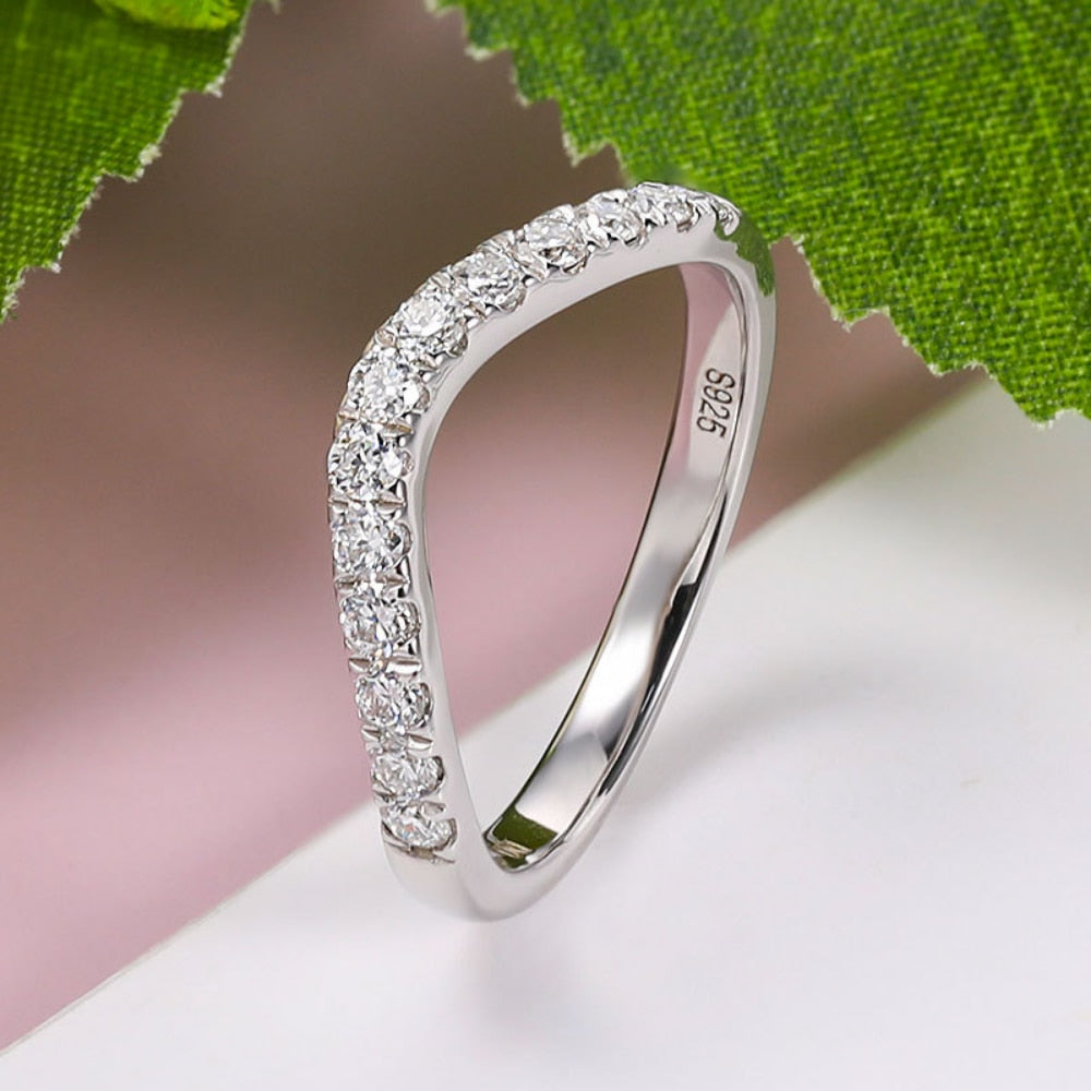 A silver curved wedding ring with 13 clear gems.