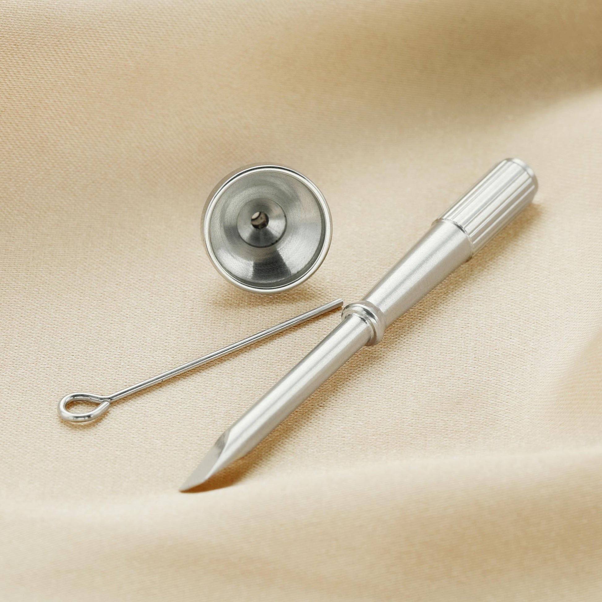 A small silver screwdriver, funnel and scoop.