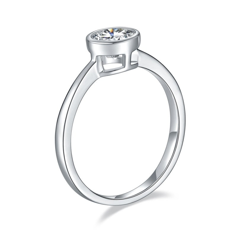 A silver round cut bezel set ring.