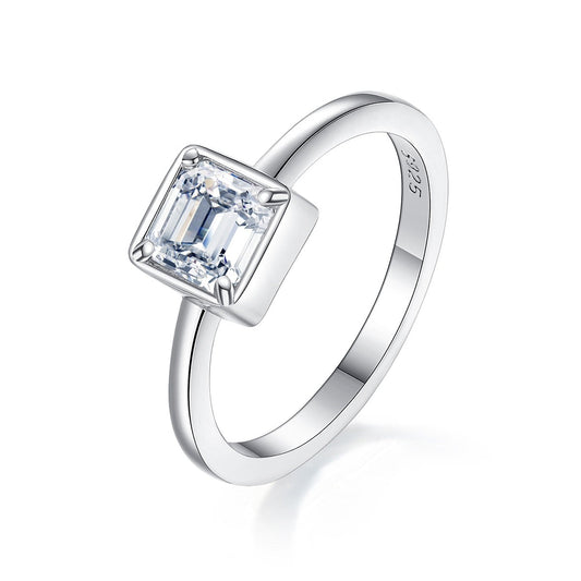 A silver Asscher cut bezel set engagement ring.