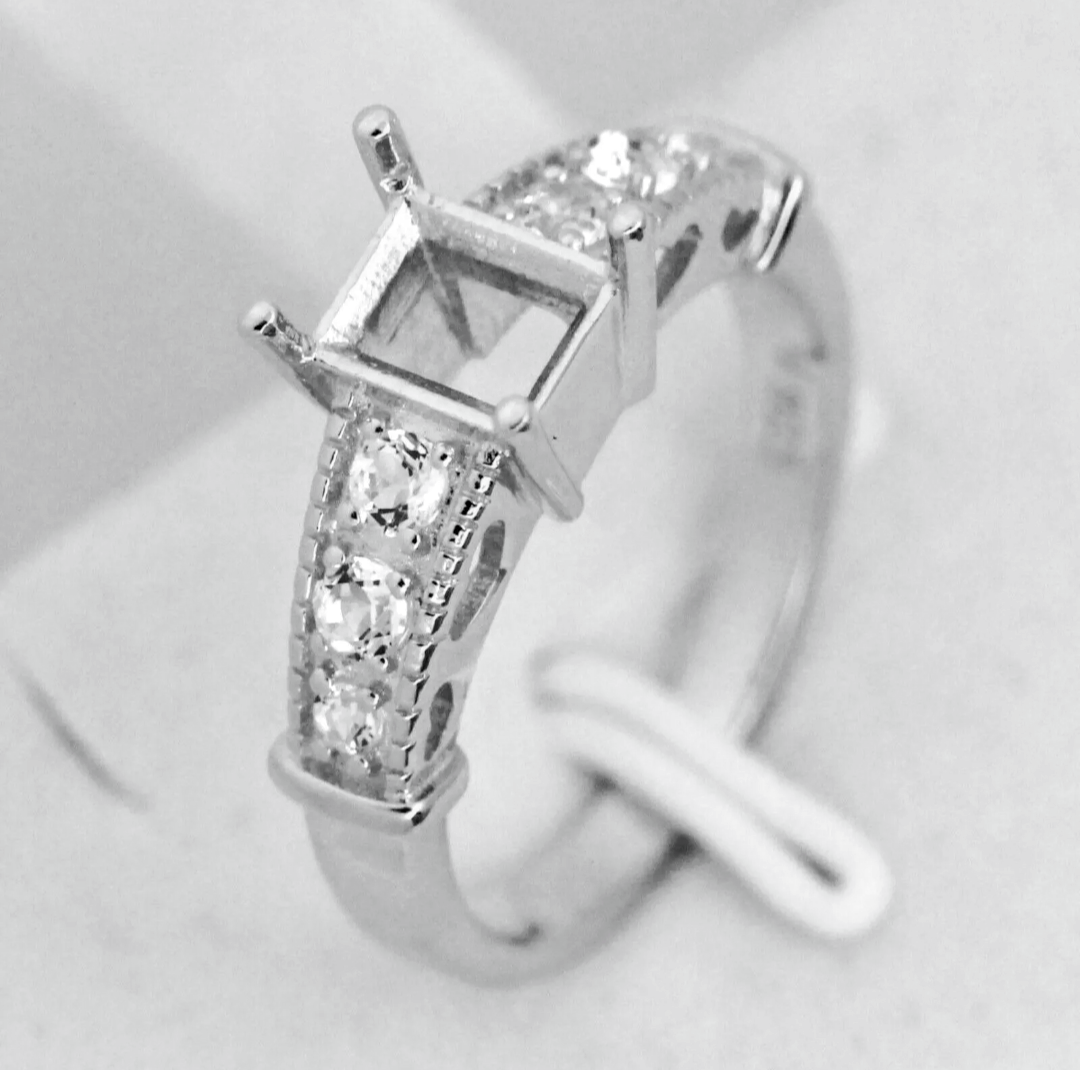 A silver semi mount with a pave filigree band made to be set with an emerald cut gem.