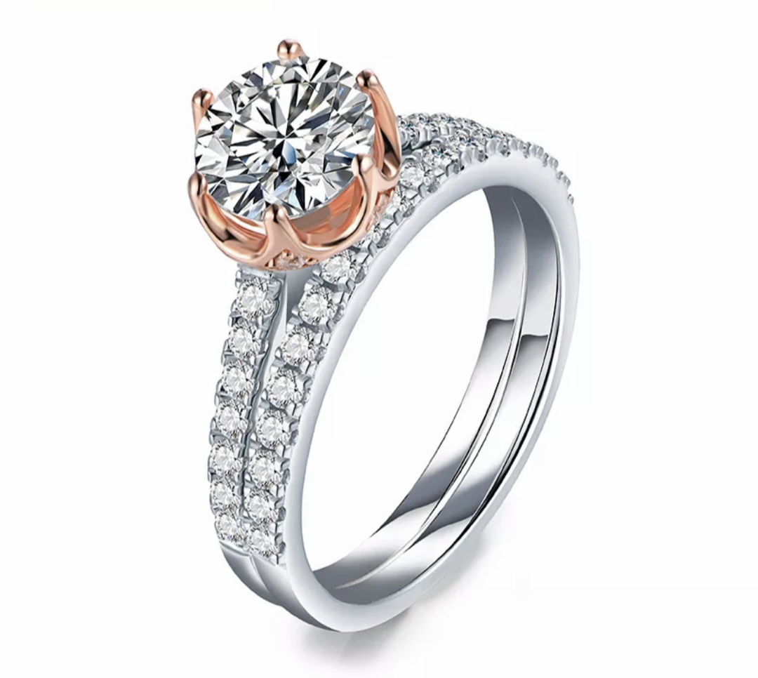 Solid sterling silver two tone rose gold and silver round cut moissanite with pave band engagement ring with matching pave wedding ring.