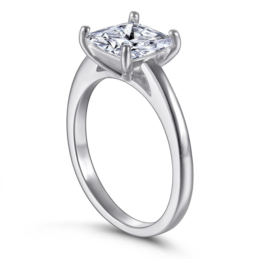 A silver ring set with a princess moissanite.