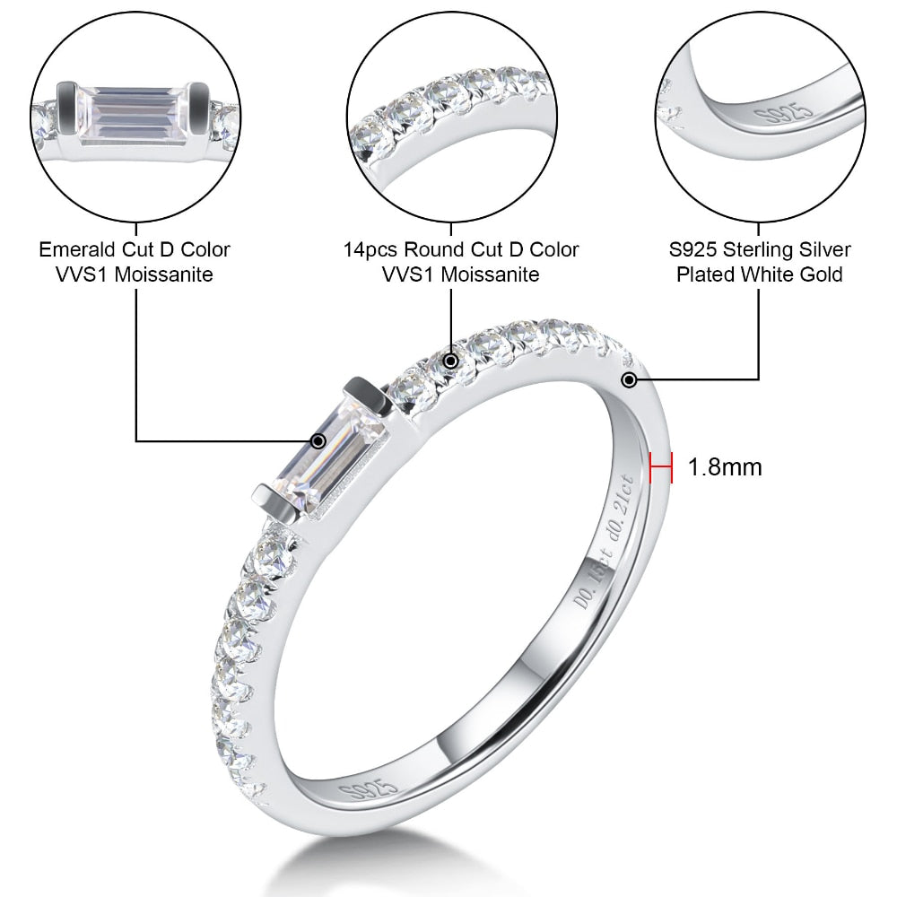 A silver stackable wedding ring tension set with a small emerald cut gem on a pave band.