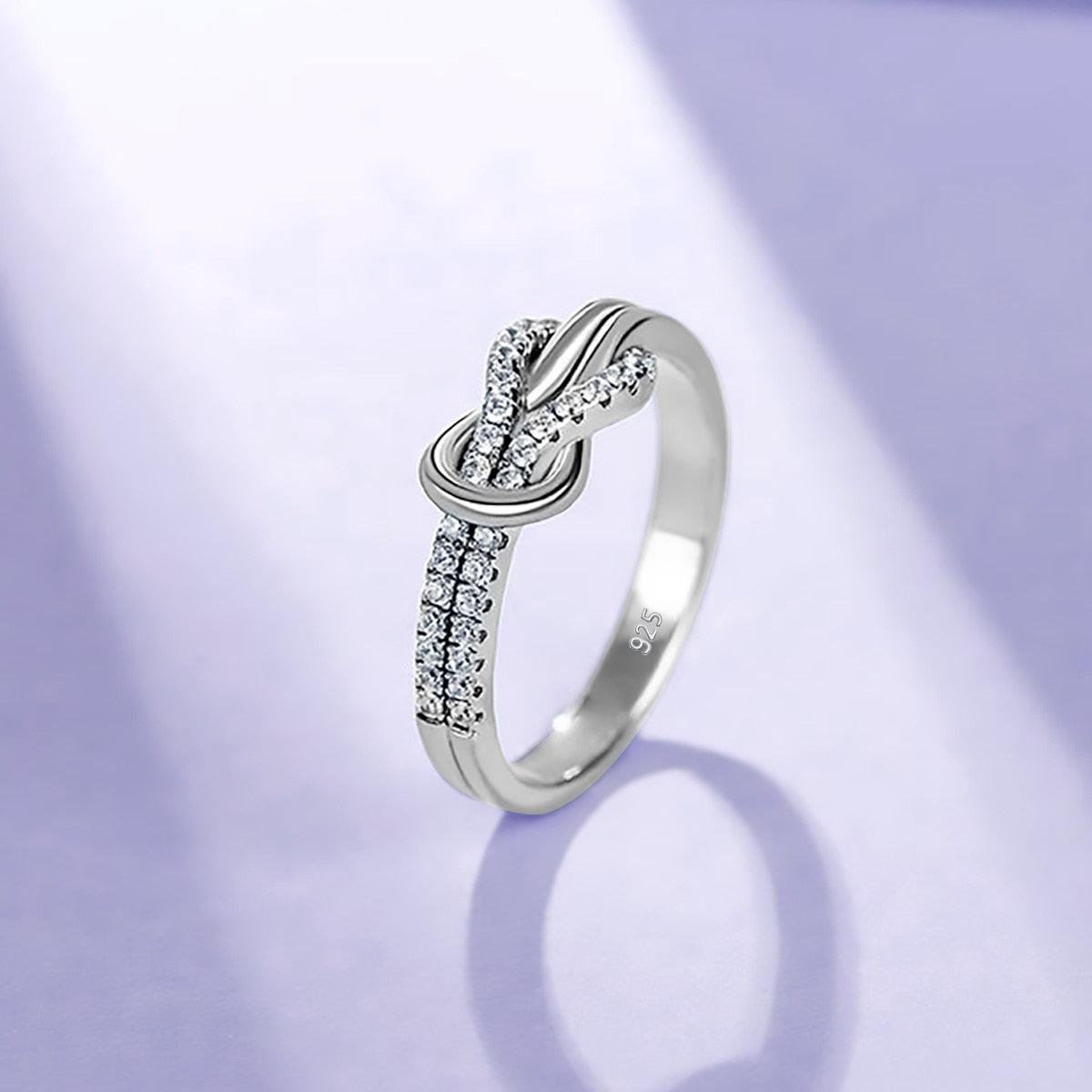 A silver half pave infinity knot ring.