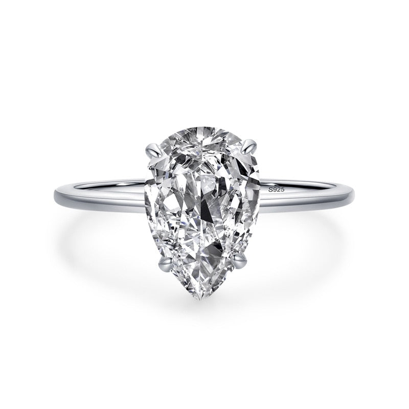 A silver solitaire ring set with a large pear cut moissanite. 