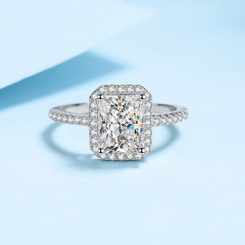 A silver halo ring set with a radiant cut moissanite.