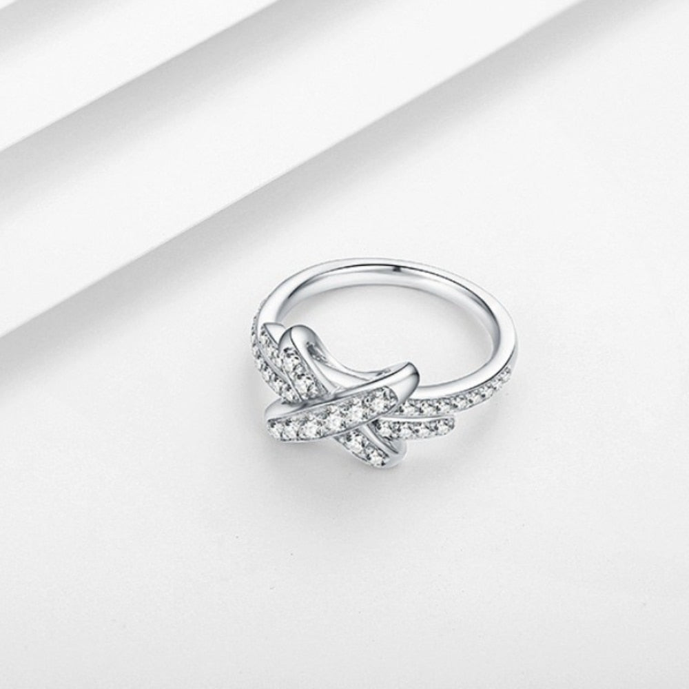A silver pave bypass ring with a X studded with sparkling moissanites.