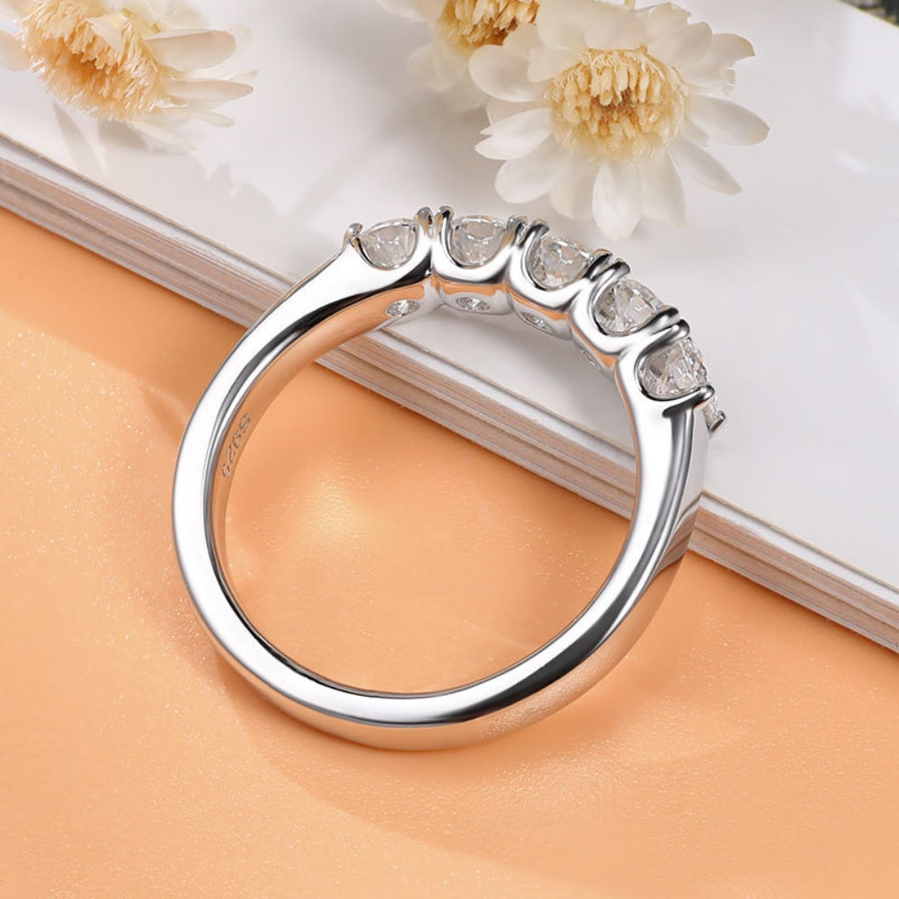A silver 5 round cut stone wedding ring.