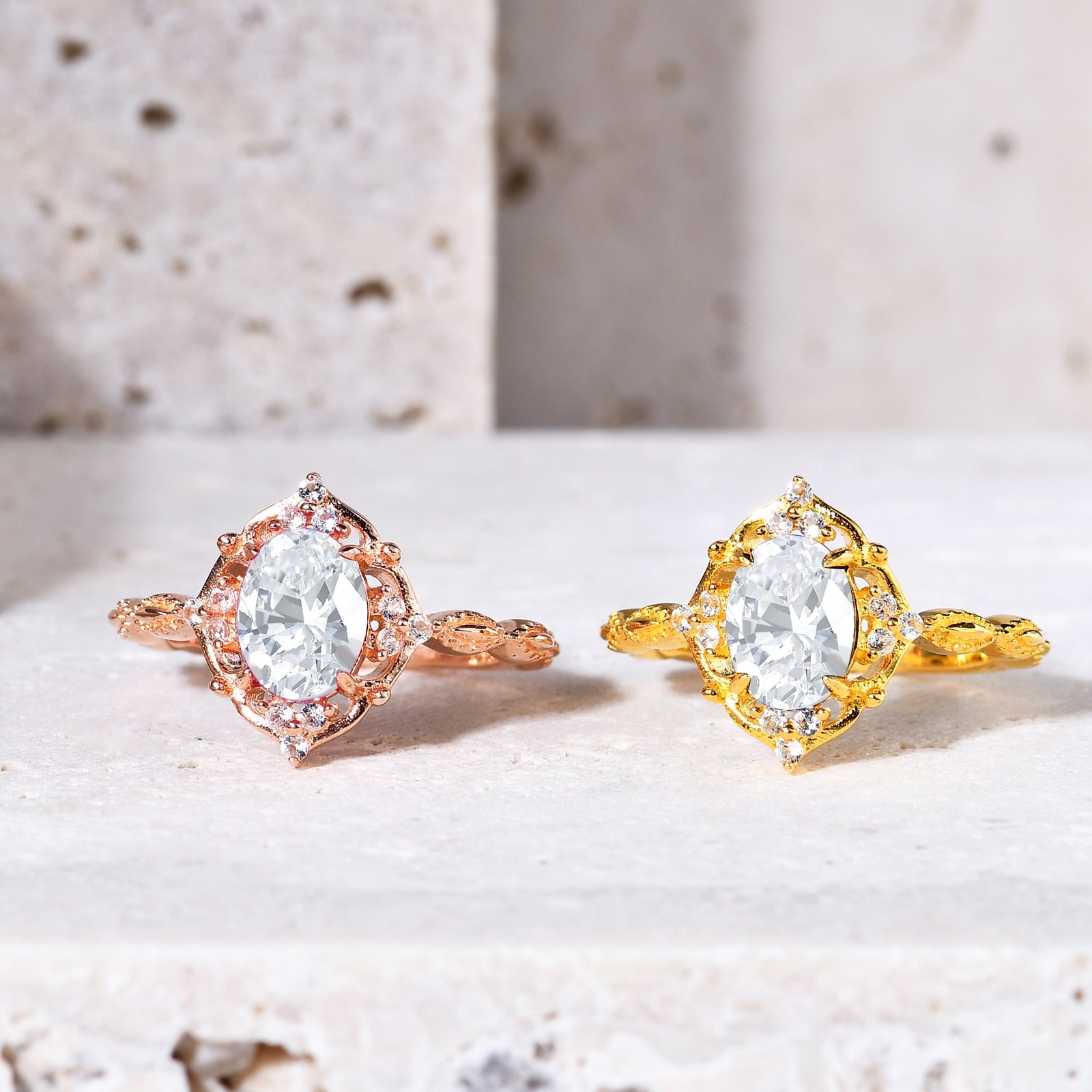 Two solid rose gold and yellow gold vintage style halo engagement rings set with an oval cut moissanites.