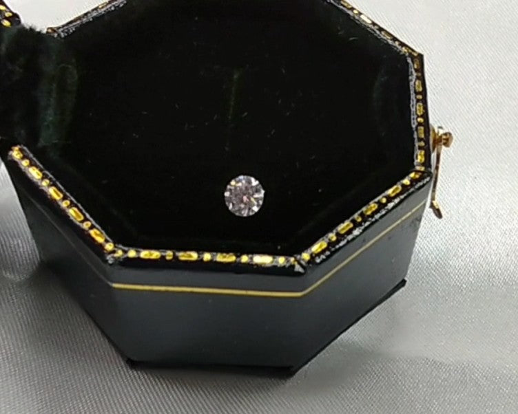 A small round cut moissanite gem.