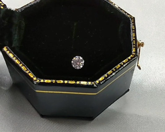 A small round cut moissanite gem.