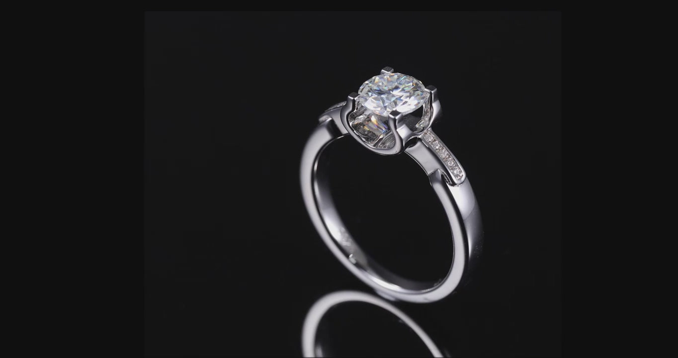 A silver tension set engagement ring with a tapered pave shank on a spinning viewing platform.